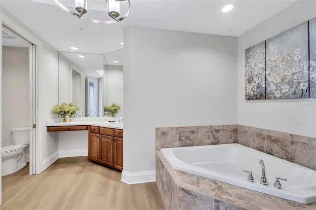 140 Riviera Dunes Way Unit 1203, Palmetto, FL 34221 - bathroom featuring toilet, a bath, wood finished floors, vanity, and a chandelier