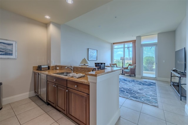 140 Riviera Dunes Way Unit 1203, Palmetto, FL 34221 - kitchen featuring a sink, a peninsula, light tile patterned floors, light stone countertops, and recessed lighting