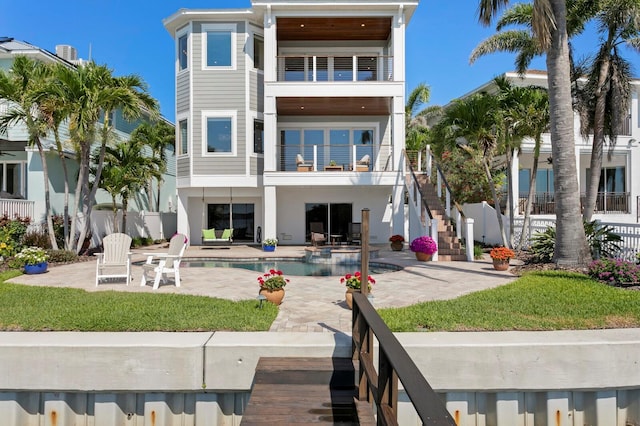 443 18th Ave, Indian Rocks Beach, FL 33785 - back of house with a balcony, a patio, an outdoor pool, stucco siding, and stairway