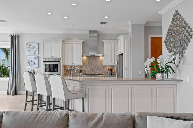 443 18th Ave, Indian Rocks Beach, FL 33785 - kitchen with wall chimney exhaust hood, appliances with stainless steel finishes, open floor plan, tasteful backsplash, and recessed lighting