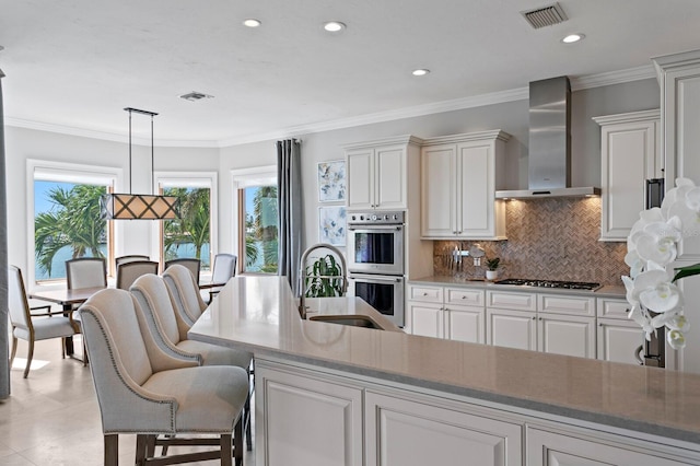 443 18th Ave, Indian Rocks Beach, FL 33785 - kitchen with wall chimney exhaust hood, stainless steel appliances, tasteful backsplash, hanging light fixtures, and recessed lighting