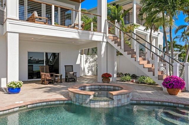 443 18th Ave, Indian Rocks Beach, FL 33785 - rear view of property featuring stairs, a patio area, a pool with connected hot tub, and stucco siding