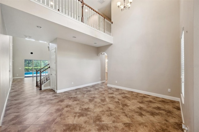 5117 Longspur Ct, Lithia, FL 33547 - unfurnished room with a chandelier, a high ceiling, baseboards, stairs, and arched walkways