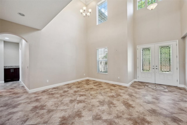 5117 Longspur Ct, Lithia, FL 33547 - tiled entryway featuring a towering ceiling, arched walkways, healthy amount of natural light, baseboards, and french doors