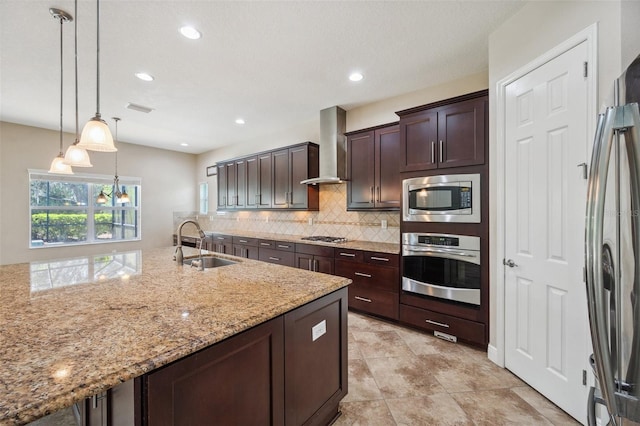5117 Longspur Ct, Lithia, FL 33547 - kitchen featuring appliances with stainless steel finishes, wall chimney exhaust hood, a sink, backsplash, and light stone counters