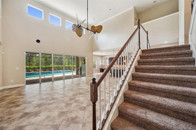 5117 Longspur Ct, Lithia, FL 33547 - stairs with healthy amount of natural light, a towering ceiling, baseboards, ornamental molding, and a chandelier