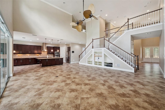 5117 Longspur Ct, Lithia, FL 33547 - unfurnished living room with a high ceiling, stairway, baseboards, ornamental molding, and french doors