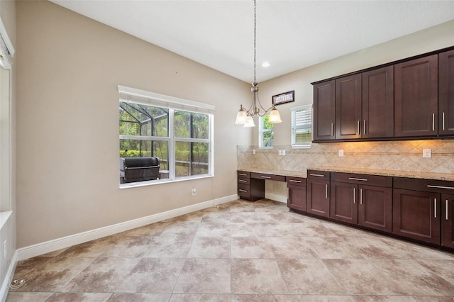 5117 Longspur Ct, Lithia, FL 33547 - kitchen with decorative backsplash, dark brown cabinets, baseboards, decorative light fixtures, and light stone counters