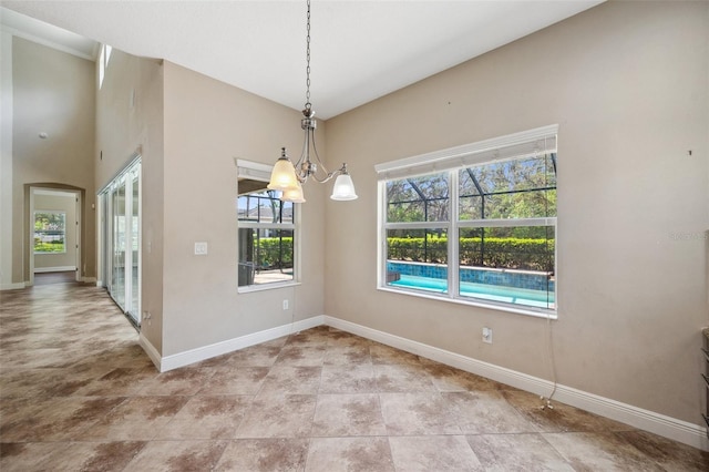 5117 Longspur Ct, Lithia, FL 33547 - unfurnished dining area featuring baseboards, a chandelier, and arched walkways