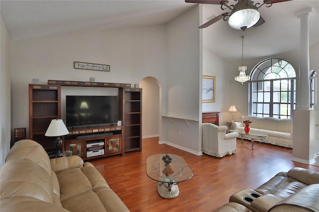 living area with lofted ceiling, ceiling fan, arched walkways, wood finished floors, and baseboards