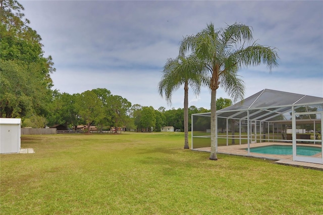 view of grassy yard featuring an outdoor pool and a lanai