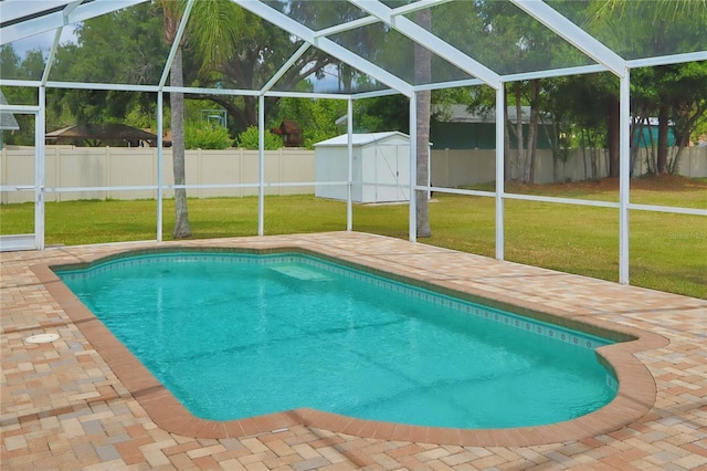 view of pool with a lanai, a storage unit, a patio area, and an outbuilding
