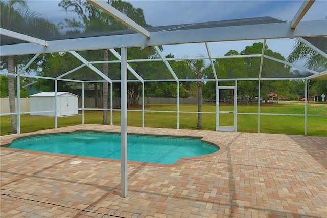 view of swimming pool featuring a patio, glass enclosure, a shed, and an outdoor structure