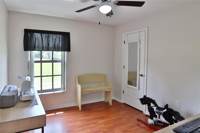 office featuring a ceiling fan, wood finished floors, and baseboards