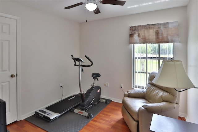 exercise room with ceiling fan, wood finished floors, and baseboards