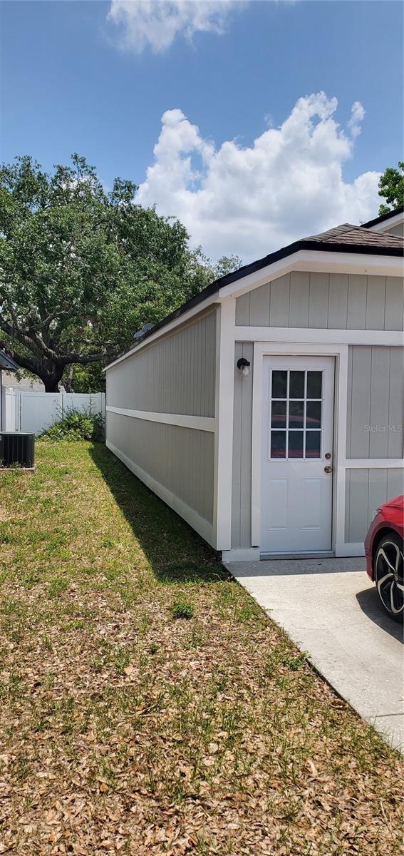 8207 Volusia Pl, Tampa, FL 33637 - view of side of property featuring board and batten siding and cooling unit