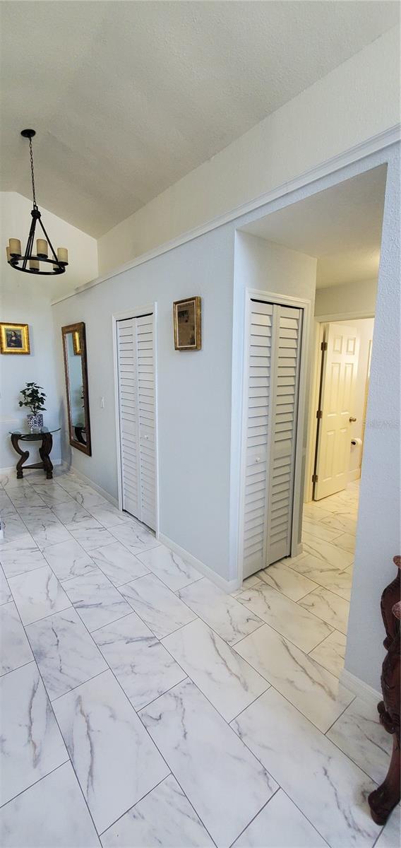 8207 Volusia Pl, Tampa, FL 33637 - unfurnished room with light marble finish floors, vaulted ceiling, and baseboards