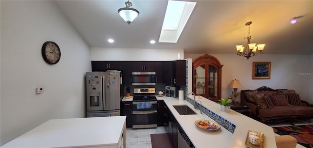 8207 Volusia Pl, Tampa, FL 33637 - kitchen featuring appliances with stainless steel finishes, a sink, a skylight, light marble finish floors, and light countertops