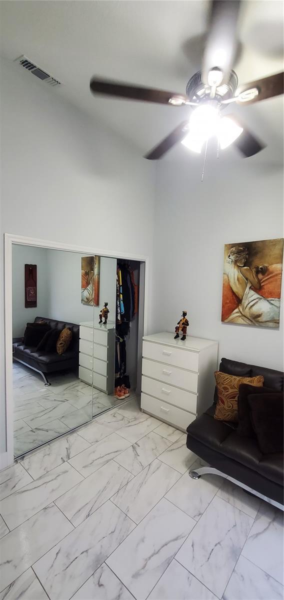 8207 Volusia Pl, Tampa, FL 33637 - bedroom with light marble finish flooring, a closet, and a ceiling fan