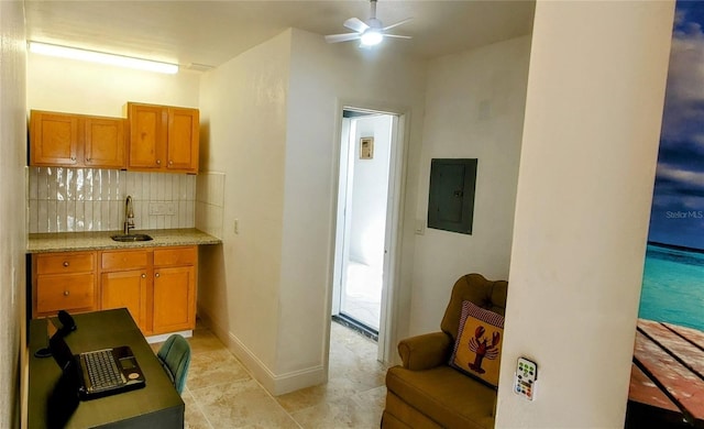 8207 Volusia Pl, Tampa, FL 33637 - kitchen featuring electric panel, tasteful backsplash, a sink, a ceiling fan, and brown cabinets