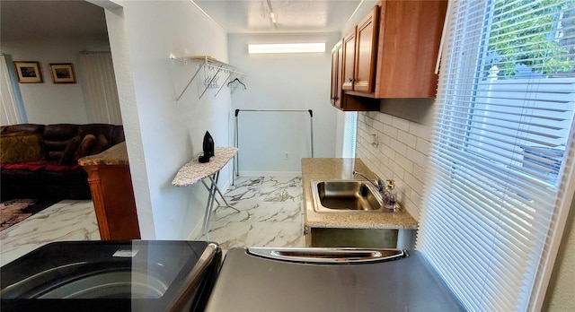 8207 Volusia Pl, Tampa, FL 33637 - kitchen with a sink, light marble finish flooring, brown cabinetry, backsplash, and light countertops