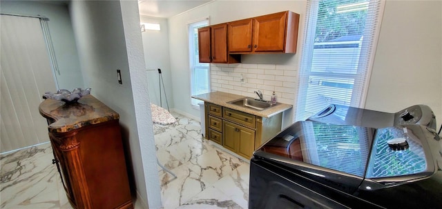 8207 Volusia Pl, Tampa, FL 33637 - kitchen featuring light marble finish floors, a sink, decorative backsplash, brown cabinetry, and light countertops