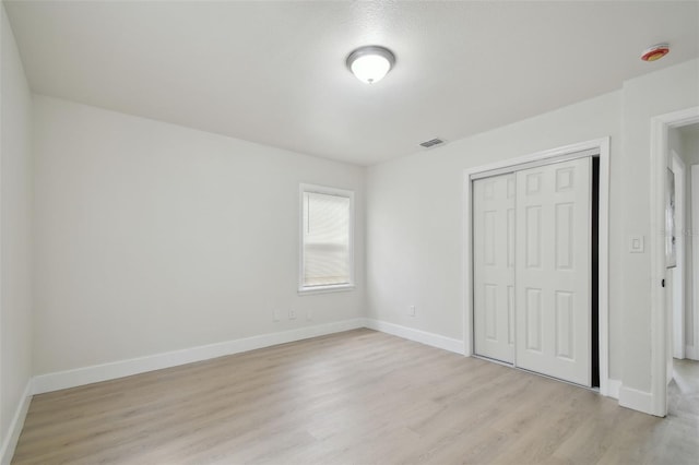 1404 E Curtis St, Tampa, FL 33603 - unfurnished bedroom featuring light wood-style floors, a closet, and baseboards