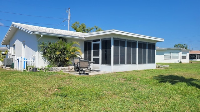 10040 38th Way N, Pinellas Park, FL 33782 - back of property featuring a sunroom, a yard, central AC unit, and stucco siding
