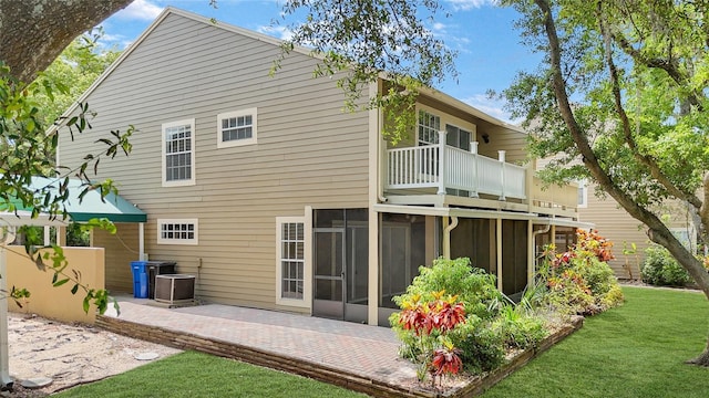 9050 Lake Place Ln, Tampa, FL 33634 - rear view of property with a balcony, a sunroom, a patio area, a yard, and central AC