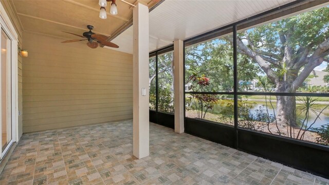 9050 Lake Place Ln, Tampa, FL 33634 - unfurnished sunroom with ceiling fan, a water view, and wooden walls