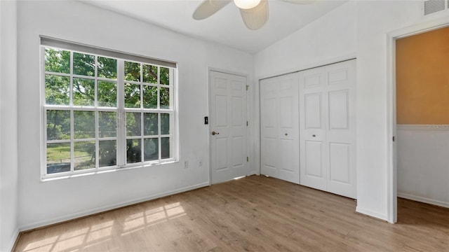 9050 Lake Place Ln, Tampa, FL 33634 - unfurnished bedroom featuring multiple windows, wood finished floors, and a closet
