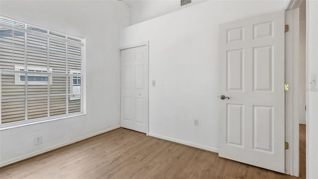 9050 Lake Place Ln, Tampa, FL 33634 - unfurnished bedroom featuring wood finished floors, baseboards, and a closet