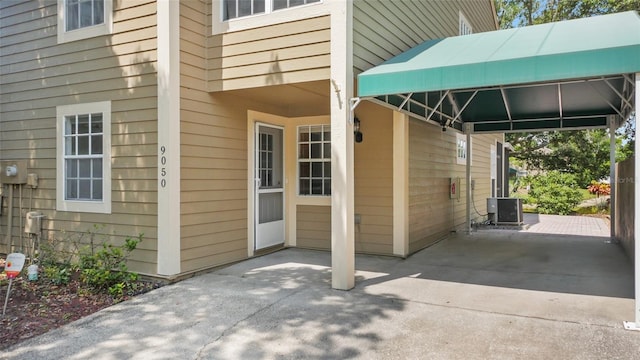 9050 Lake Place Ln, Tampa, FL 33634 - view of exterior entry with cooling unit and a carport