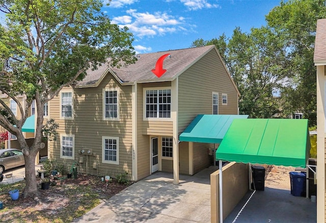 9050 Lake Place Ln, Tampa, FL 33634 - view of front of property featuring a carport, concrete driveway, and a shingled roof
