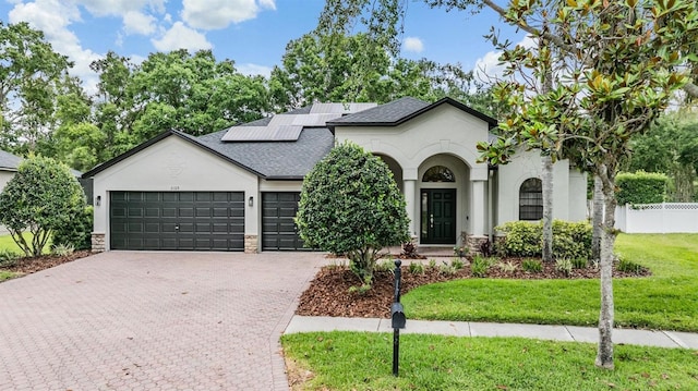 5109 Hartwell Loop, Land O Lakes, FL 34638 - french country home with stucco siding, decorative driveway, a garage, solar panels, and a shingled roof