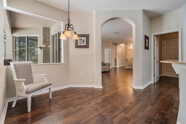 5109 Hartwell Loop, Land O Lakes, FL 34638 - unfurnished room with arched walkways, dark wood finished floors, a chandelier, and baseboards