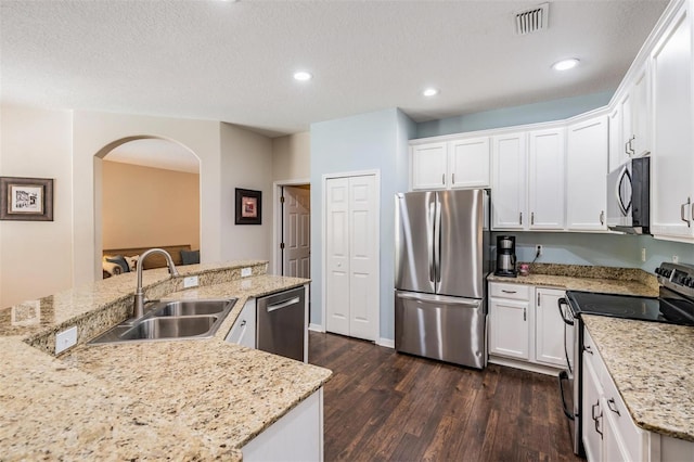 5109 Hartwell Loop, Land O Lakes, FL 34638 - kitchen with appliances with stainless steel finishes, a sink, arched walkways, dark wood finished floors, and white cabinets