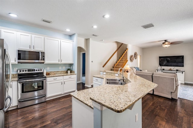 5109 Hartwell Loop, Land O Lakes, FL 34638 - kitchen with stainless steel appliances, a sink, arched walkways, open floor plan, and dark wood-type flooring