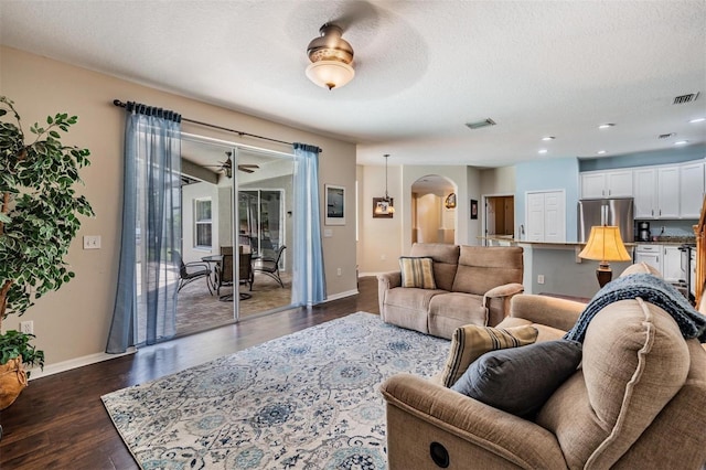 5109 Hartwell Loop, Land O Lakes, FL 34638 - living area featuring a ceiling fan, arched walkways, dark wood-style flooring, a textured ceiling, and baseboards