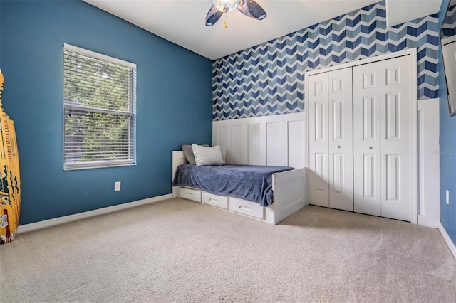 5109 Hartwell Loop, Land O Lakes, FL 34638 - carpeted bedroom featuring baseboards, wallpapered walls, an accent wall, a closet, and ceiling fan