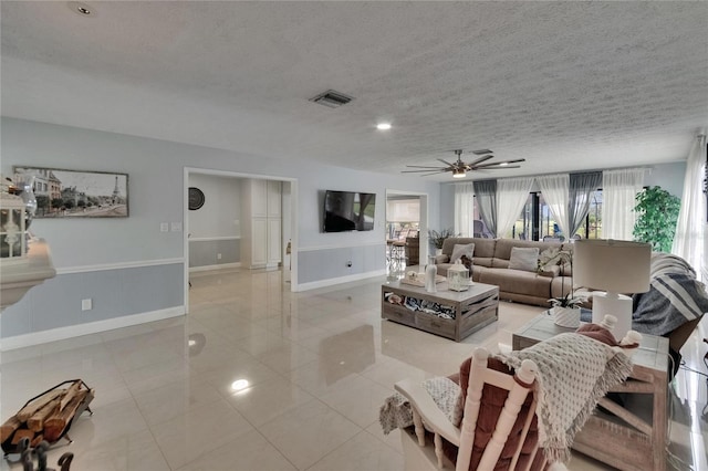 2219 Summit View Dr, Valrico, FL 33596 - living room featuring a ceiling fan, baseboards, light tile patterned floors, and a textured ceiling