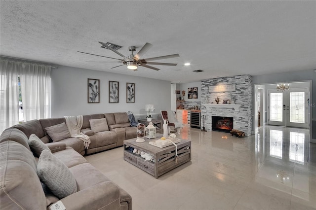 2219 Summit View Dr, Valrico, FL 33596 - living room featuring a chandelier, a ceiling fan, beverage cooler, a textured ceiling, and a fireplace