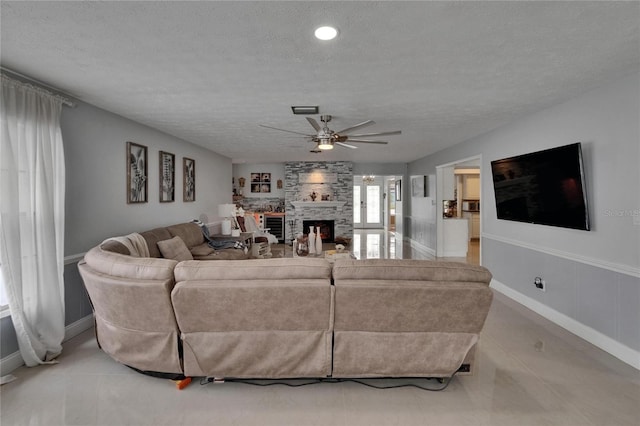 2219 Summit View Dr, Valrico, FL 33596 - living area with a ceiling fan, a textured ceiling, a fireplace, and baseboards