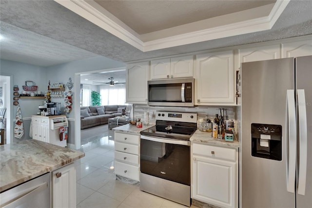 2219 Summit View Dr, Valrico, FL 33596 - kitchen featuring appliances with stainless steel finishes, light tile patterned floors, white cabinetry, and a textured ceiling