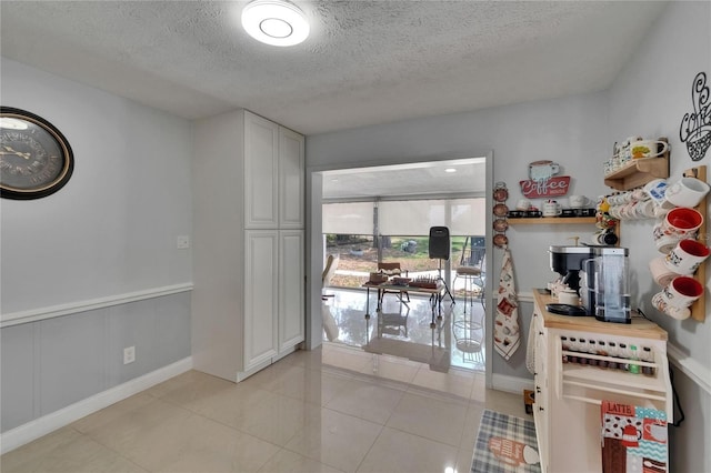 2219 Summit View Dr, Valrico, FL 33596 - kitchen featuring a textured ceiling, baseboards, and light tile patterned floors