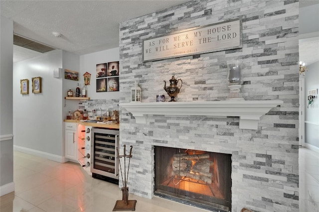 2219 Summit View Dr, Valrico, FL 33596 - indoor wet bar with wine cooler, light tile patterned floors, baseboards, a textured ceiling, and a fireplace