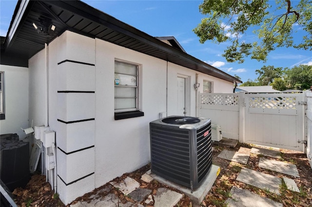 2219 Summit View Dr, Valrico, FL 33596 - exterior view of cooling unit, fence, and stucco siding