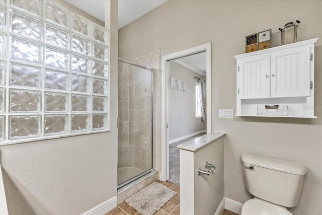 bathroom featuring a tile shower, toilet, tile patterned floors, and baseboards