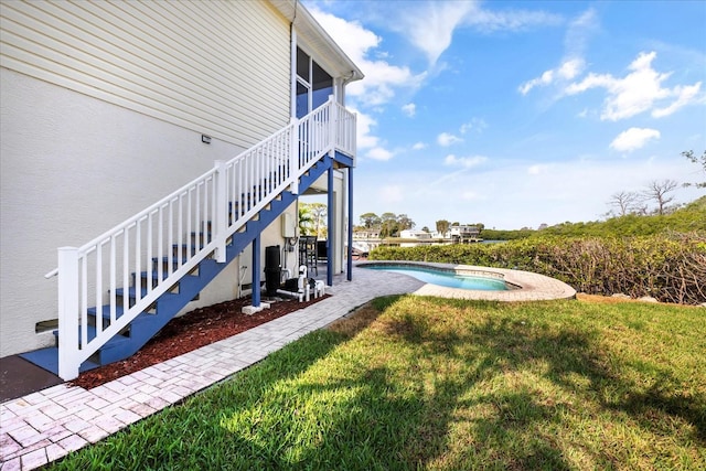swimming pool with stairway, a yard, and a patio area