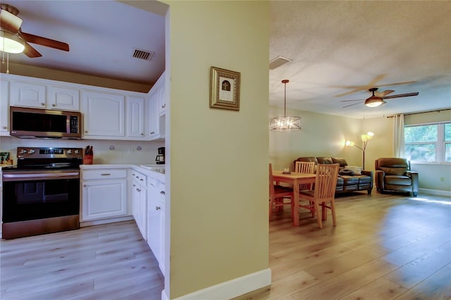 2913 Fig Ct, Palm Harbor, FL 34684 - kitchen with appliances with stainless steel finishes, a ceiling fan, light wood finished floors, and white cabinets